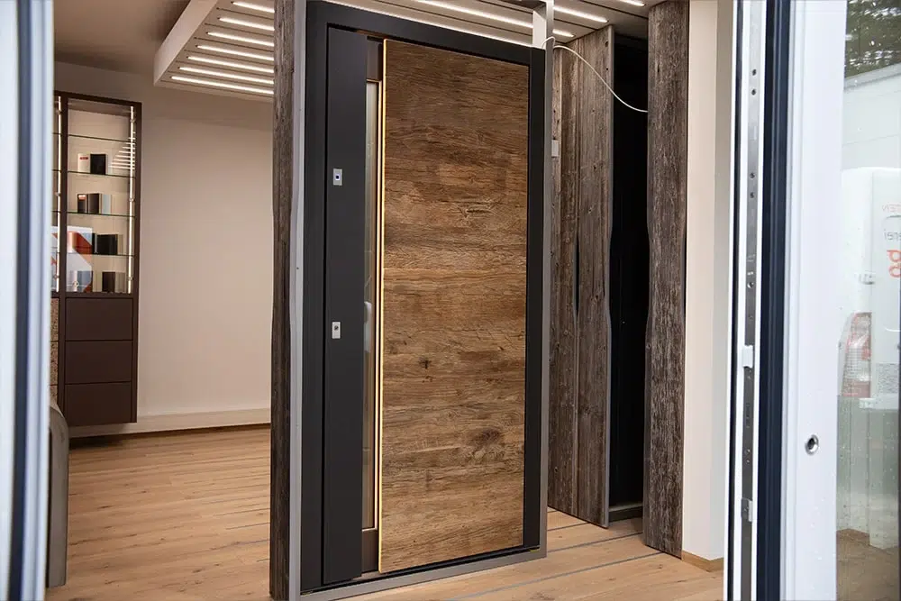 Moderne Haustür mit Holzoptik und schwarzem Rahmen in einem hellen Türen-Showroom